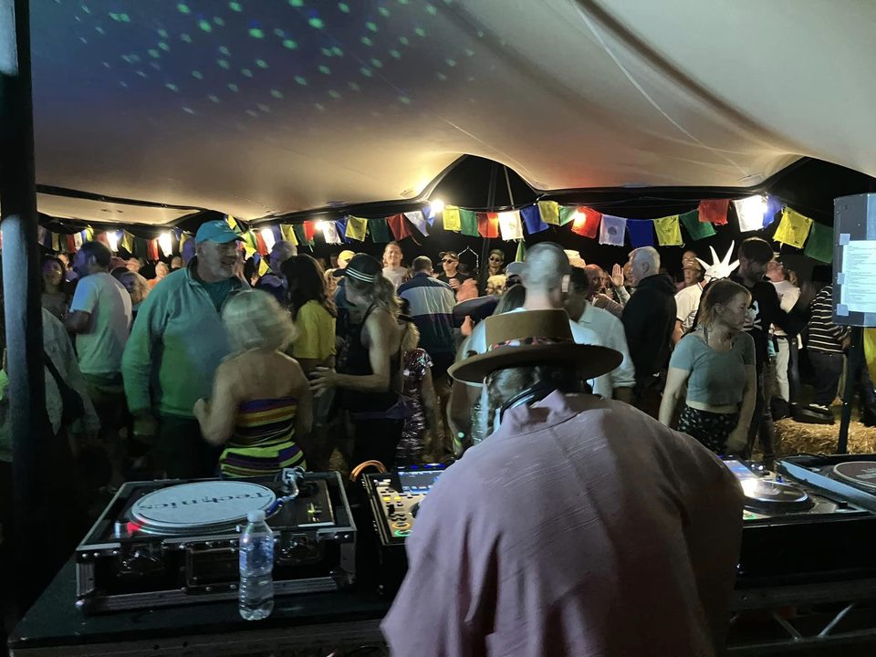 A DJ in a straw hat playing to a full Chill Out Tent at We Are Love 2024